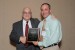 Dr. Nagib Callaos, General Chair, giving Mr. J. Prezzama a plaque in appreciation for co-presenting a Plenary Keynote Address, titled "Fostering Partnerships between Industry and Academia to promote Science, Technology, Engineering and Mathematics Education."